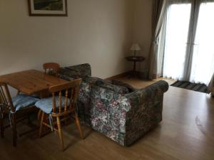 a living room with a couch and a wooden table at Lazy Daisys in Langsett +5 photos