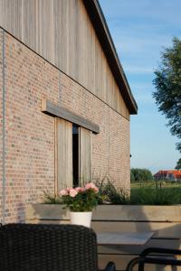 - un bâtiment en briques avec une fenêtre fleurie dans l'établissement Ruiterhof B&B/Hostel, à Bredene