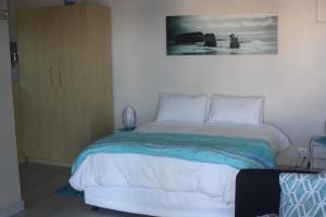 1 dormitorio con 1 cama con una foto en la pared en Ocean Sunset, en Seaview