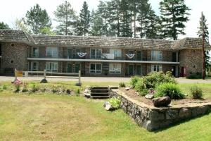 a large brick building with a garden in front of it at Budget Host Inn in Ironwood