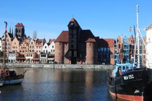 two boats are docked in the water near a city at Gdańsk-Apartament Jaglana Spa in Gdańsk