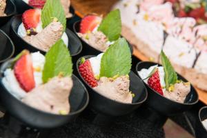 a row of black cups filled with strawberries and ice cream at Atrium Hotel Thassos in Potos