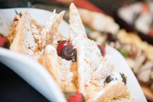 a piece of cake with a strawberry on a white plate at Atrium Hotel Thassos in Potos