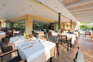 a restaurant with white tables and chairs and windows at Atrium Hotel Thassos in Potos