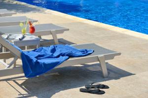 a picnic table next to a swimming pool with a blue blanket at Atrium Hotel Thassos in Potos