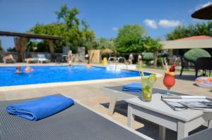 a pool with a table with a drink on it at Atrium Hotel Thassos in Potos