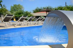 a water fountain in front of a swimming pool at Atrium Hotel Thassos in Potos