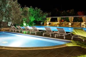 a swimming pool with lounge chairs and a table at Atrium Hotel Thassos in Potos