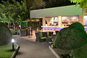 a restaurant with chairs and a bar at night at Atrium Hotel Thassos in Potos