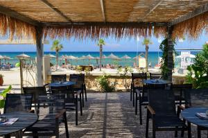 a restaurant with tables and chairs and the beach at Atrium Hotel Thassos in Potos