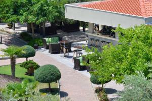 an outdoor patio with chairs and tables and trees at Atrium Hotel Thassos in Potos