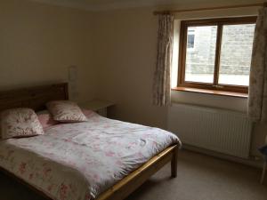 a bedroom with a bed and a window at Lazy Daisys in Langsett