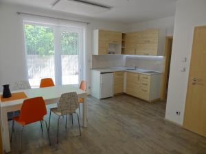 una cucina con tavolo e sedie arancioni di Apartmány Starovice a Starovice