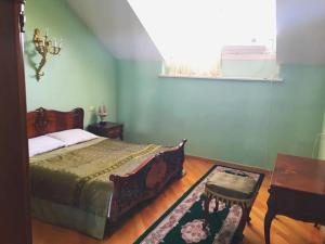 a bedroom with a bed and a table and a window at Apartament Balakhvani in Kutaisi