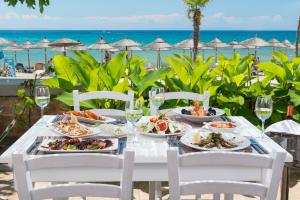 a table with plates of food on the beach at Atrium Hotel Thassos in Potos