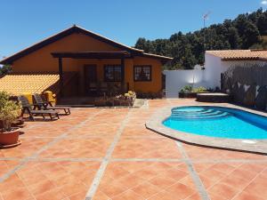 un patio con piscina frente a una casa en La Chosita, en Icod de los Vinos