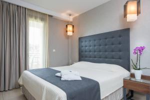 a bedroom with a large bed with a black headboard at Atrium Hotel Thassos in Potos
