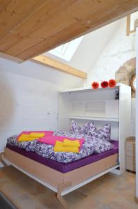 a bedroom with a bed with purple sheets and colorful pillows at Bornmüllerturm in Suhl