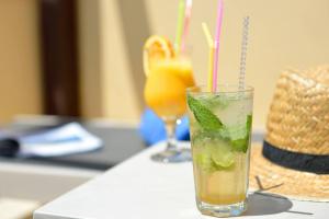 a drink in a glass with a lime and mint at Atrium Hotel Thassos in Potos
