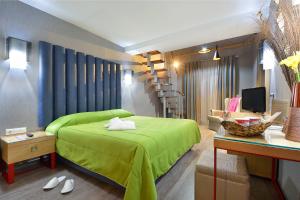 a bedroom with a green bed and a staircase at Atrium Hotel Thassos in Potos