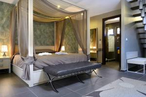 a bedroom with a canopy bed with a bench at Atrium Hotel Thassos in Potos