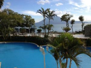 a blue swimming pool with a view of the water at Torres de Atitlán Pent-House 10 personas - Apartamento 8 personas in Panajachel