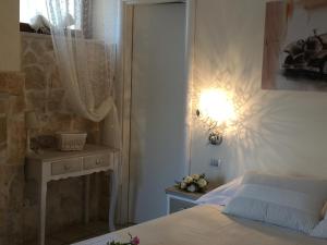 a bedroom with a bed and a table with a lamp at B&B Villa Cassandra in Castellana Grotte