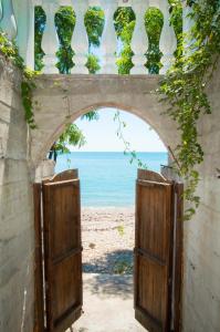 une arche avec deux portes menant à la plage dans l'établissement Villa Afon, à Nouvel Athos