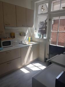 a kitchen with a sink and a microwave at Vakantiewoning Oude markt Centrum in Vlissingen