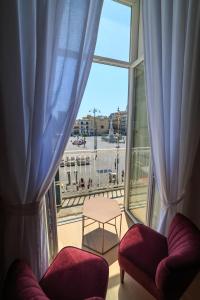 a room with two chairs and a large window at The Dante House by House In Naples in Naples