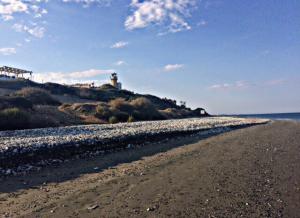 a dirt road leading to a lighthouse on a beach at Villa Galleria in Perivolia