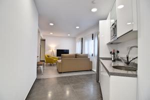 cocina y sala de estar con sofá y lavamanos en Apartamento Soho, en Málaga