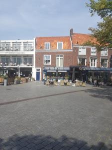 un patio con mesas y sillas frente a un edificio en Vakantiewoning Oude markt Centrum, en Vlissingen