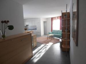 a kitchen and living room with a blue couch at Don Camillo Gästehaus in Hörhausen