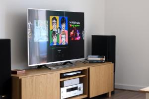 a flat screen tv sitting on top of a wooden entertainment center at Ventoux in Aviemore