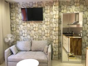 ein Wohnzimmer mit einem Sofa und einem TV an der Wand in der Unterkunft Apartamenty 66 c in Wisła