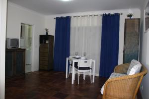 ein Wohnzimmer mit einem Tisch und einem blauen Vorhang in der Unterkunft Ar Puro II in Viana do Castelo