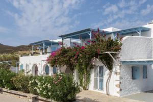 a white house with flowers on the side of it at Ergina Summer Resort in Antiparos