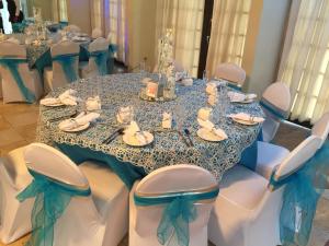 mesa con sillas blancas y mantel azul en Grand Hotel Excelsior Port Royal, en Kingston