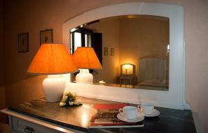 a table with two lamps and a mirror at Country House Le Case Coloniche in Deruta