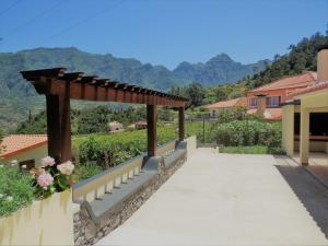 einen Gehweg zu einem Haus mit einer Pergola in der Unterkunft Casa das Ginjas in São Vicente