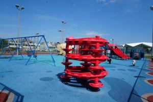 een speeltuin met een rode glijbaan in een park bij Sunset Beach Hotel in Wildwood