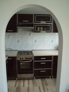 a kitchen with an archway with a stove and cabinets at Budget Stay in Szczecin