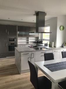 a kitchen with stainless steel appliances and a table with chairs at Kornspeicher in Nörten-Hardenberg