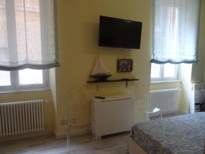 a bedroom with a bed and a tv on the wall at Suites Margot in Santa Margherita Ligure