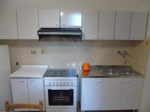 a kitchen with white cabinets and a stove and a sink at La casa sul mare in Riva Ligure +4 photos