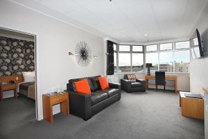 ein Wohnzimmer mit einem Sofa und einem Stuhl in der Unterkunft Kelvin Hotel in Invercargill