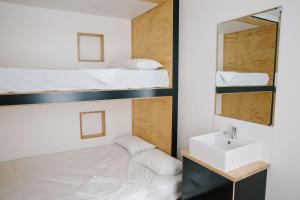 a hotel room with two beds and a mirror at Woopi Backpackers in Woolgoolga