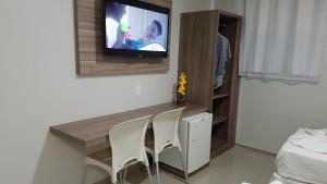 a room with two chairs and a tv on a wall at Max Hotel in Arcoverde