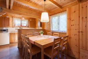 a dining room with a table and chairs in a kitchen at Sosnowa Mila in Pobierowo